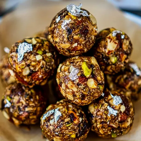 Date & Nut Laddu — dark date-and-nut laddus with silver leaf