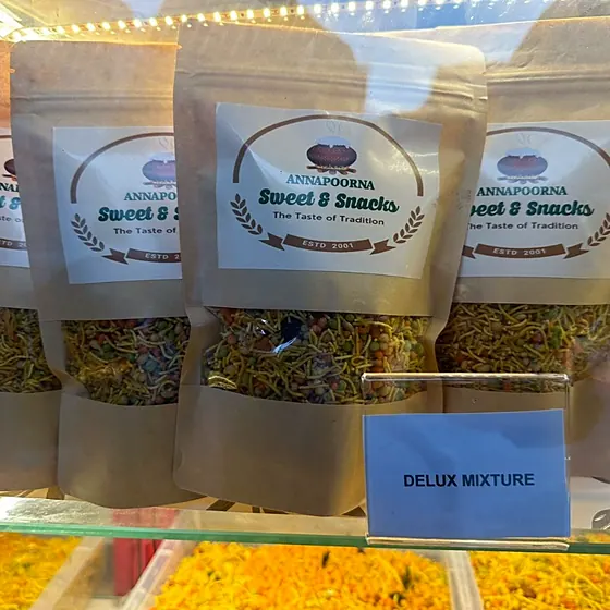Deluxe Mixture — annapoorna "Sweet & Snacks" pouches over a tray labelled "DELUX MIXTURE"