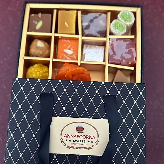 Grand Assortment Box — 12-compartment box in an Annapoorna-labelled diamond-pattern bag
