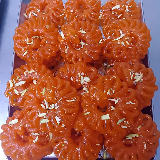 Jangiri — tray of jangiri with almond slivers