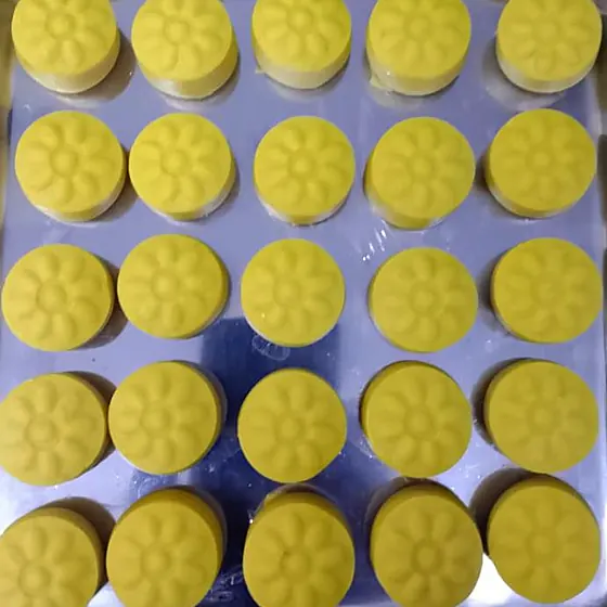 Kesar Peda — moulded saffron-yellow pedas on a shop tray