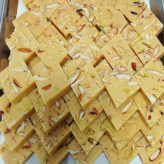 Pista Badam Burfi — pale burfi diamonds with almond and pistachio slivers on a tray