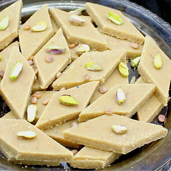 Pista Badam Burfi — burfi diamonds with pistachio on a steel plate