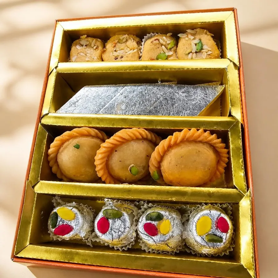 Gold Four-Tier Gift Box on an ivory plate — Annapoorna Sweets